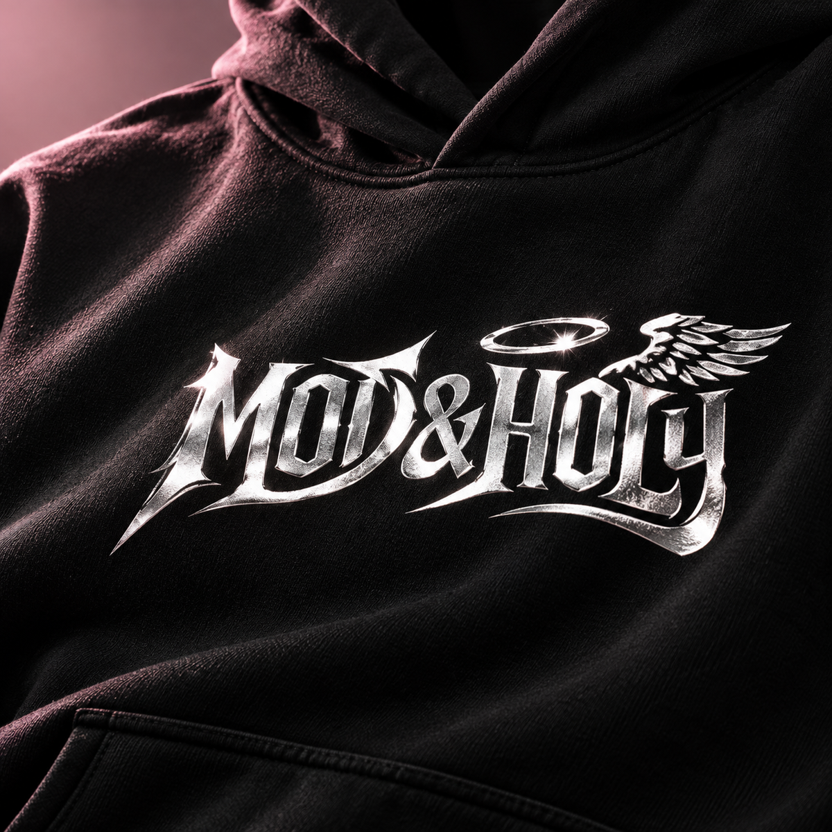 Close detail of the silver Mod & Holy halo and wing graphic on black fabric.
