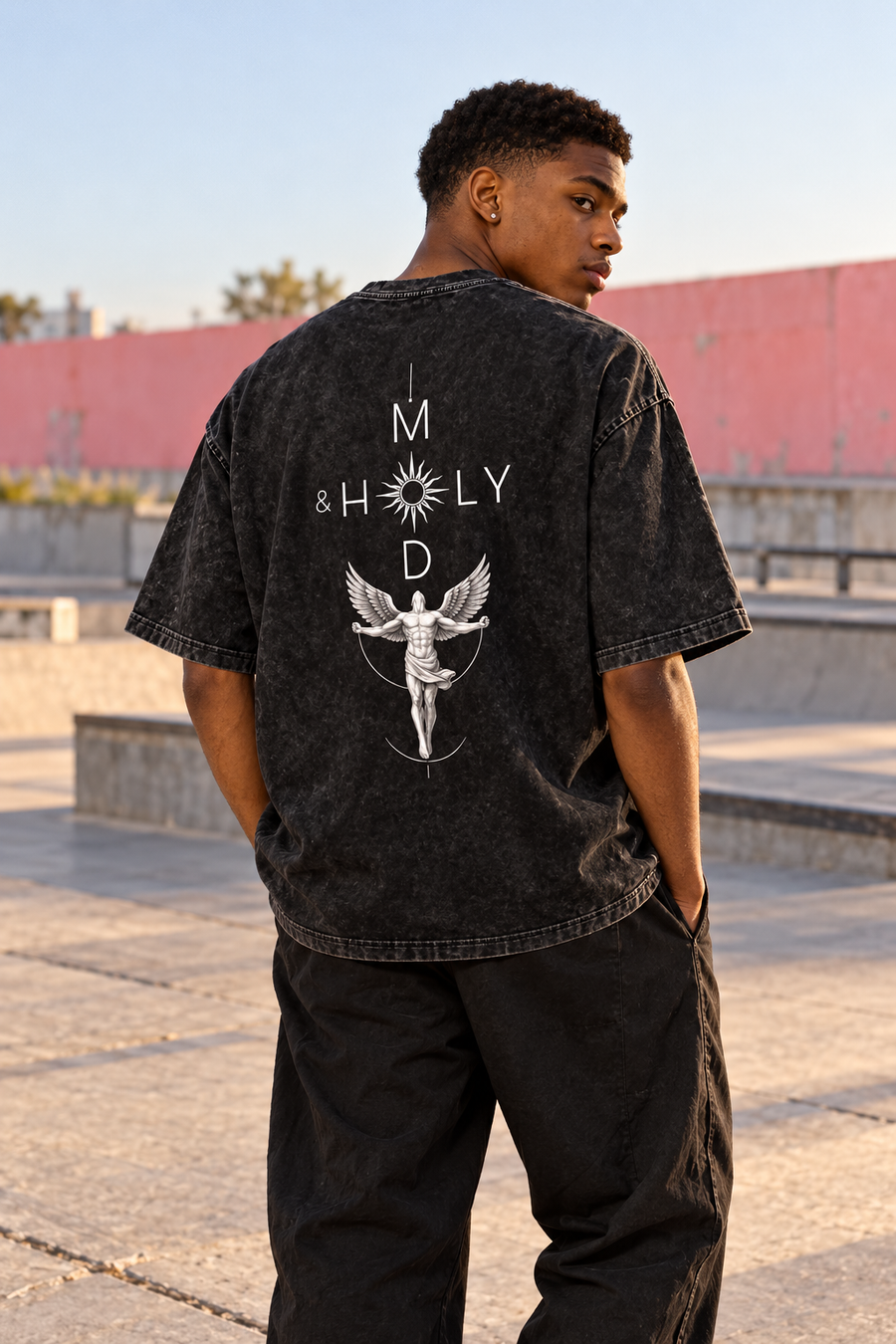 Young adult showing the angel artwork on the back of the washed-black tee.