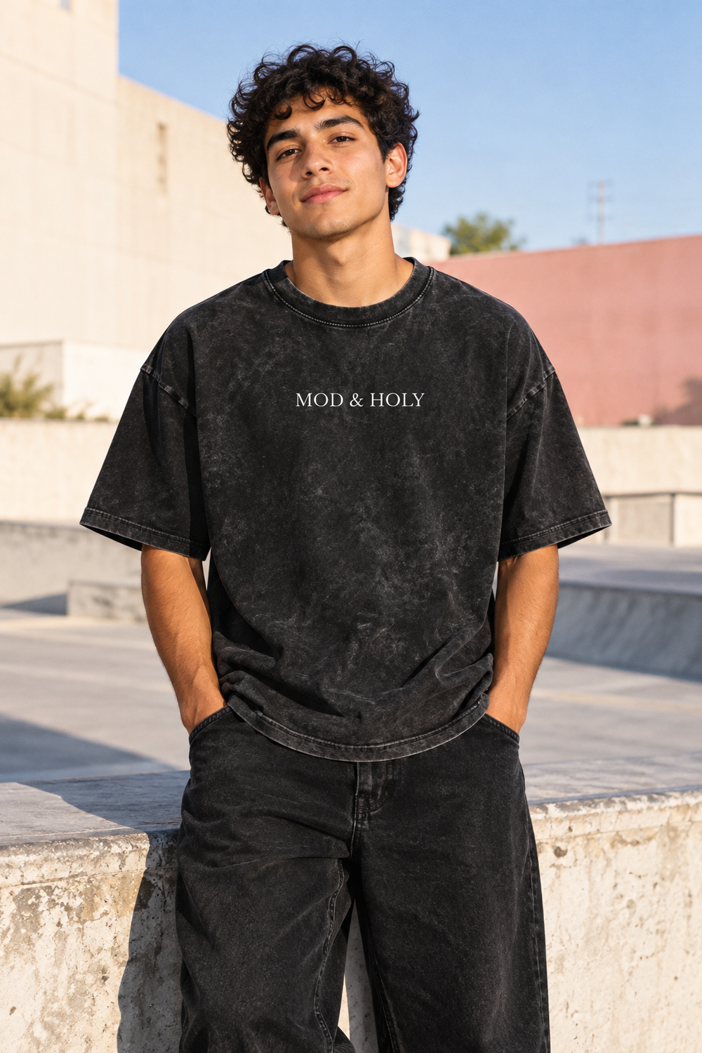 Young adult wearing the washed-black Mod and Holy tee, front view.